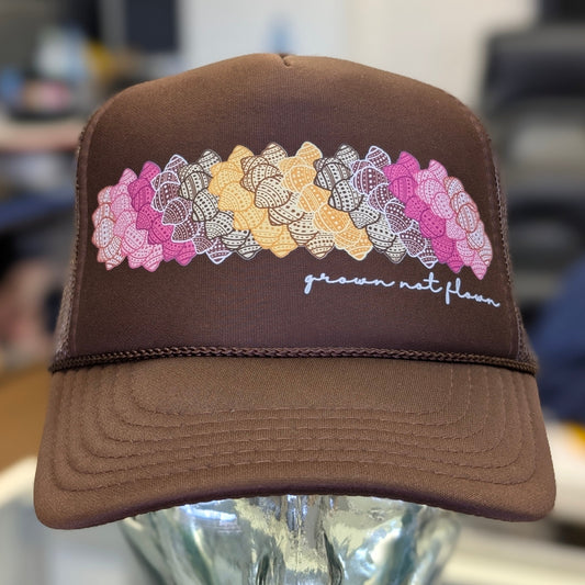 Brown foam trucker hat with colorful shell design and text on a mannequin head against a blurred background