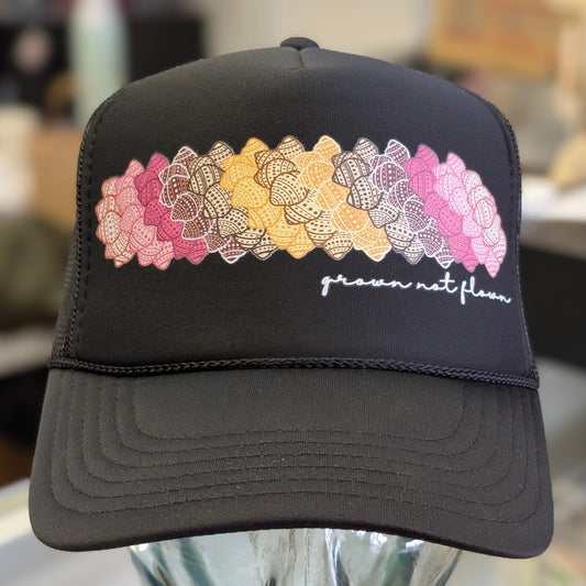 Black foam trucker hat with colorful shell design and text on a mannequin head against a blurred background